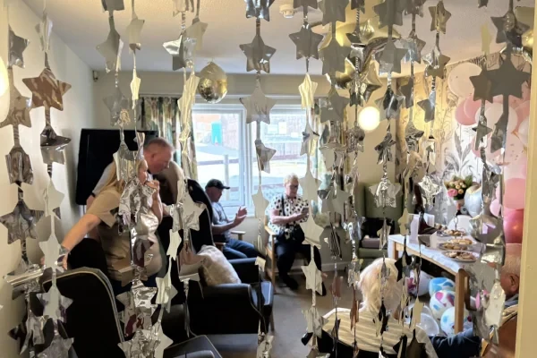 Residents enjoying a party in a lounge decorated with hanging stars