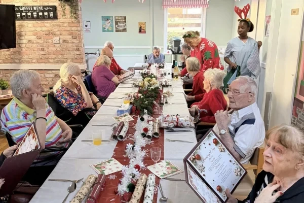 Residents enjoying a festive meal together at a long dining table
