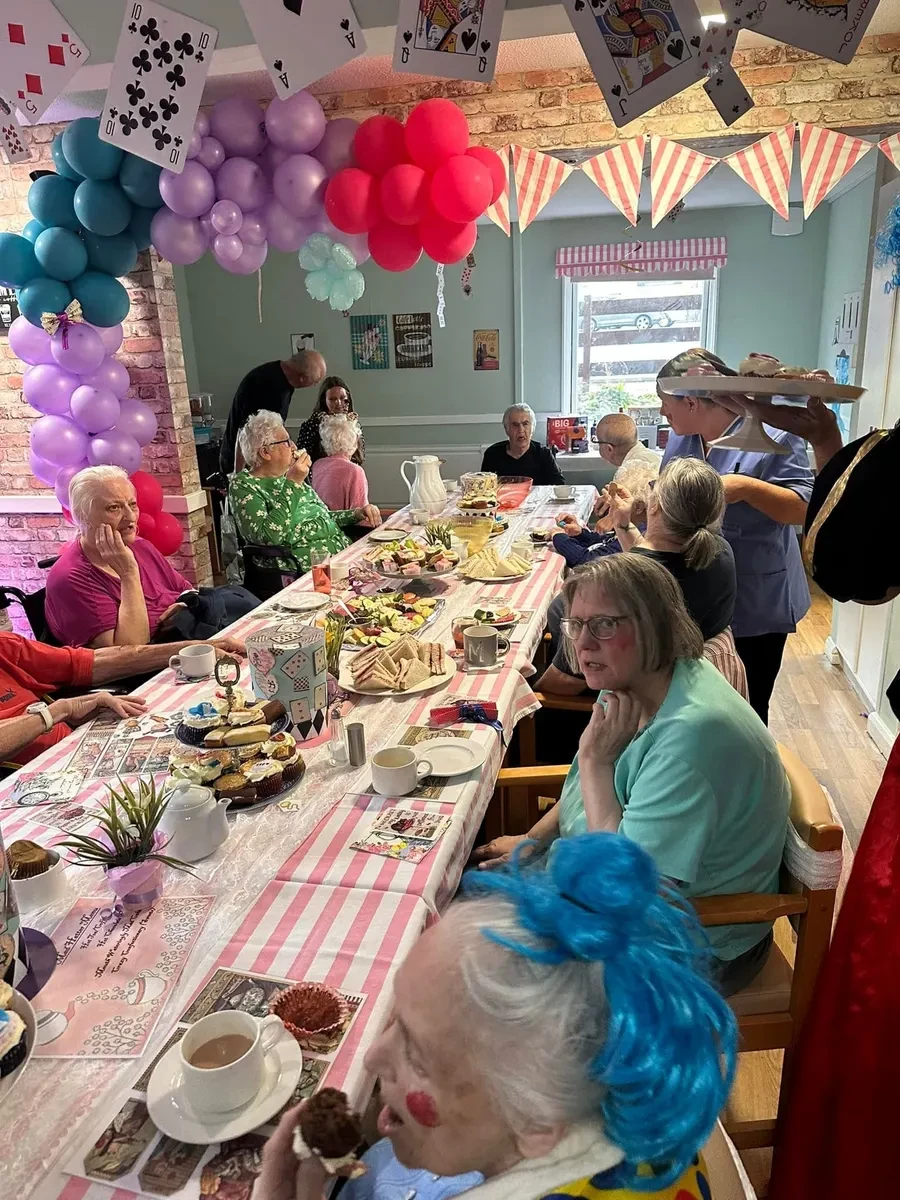 Residents and care staff enjoying a themed afternoon tea together