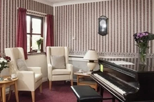 A lounge with armchairs and a piano